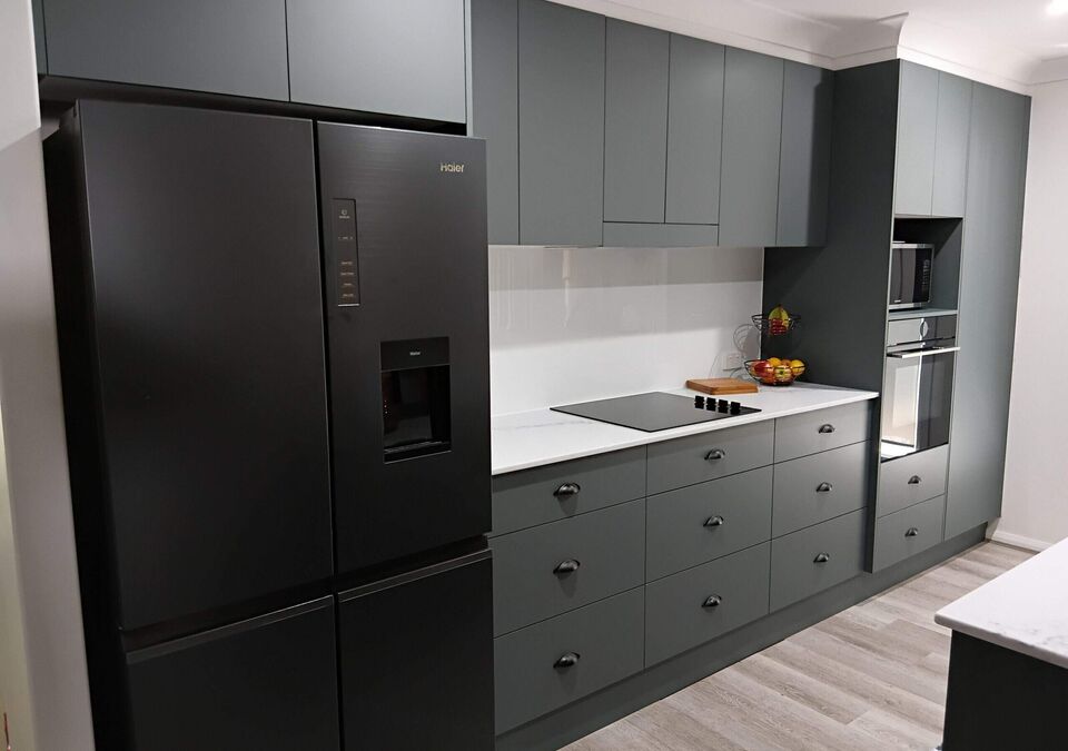 A grey kitchen with a white stone benchtop