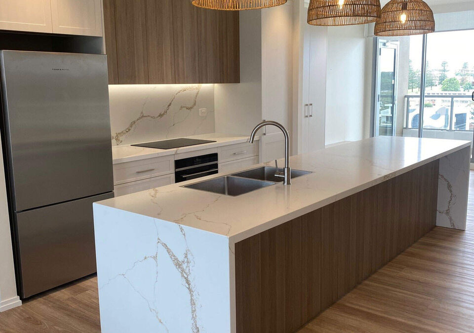 A modern kitchen with a white stone island