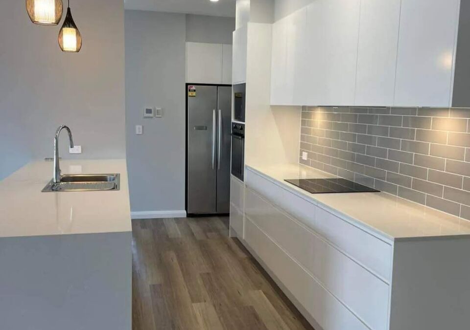 A white stone kitchen island with dark cabinetry