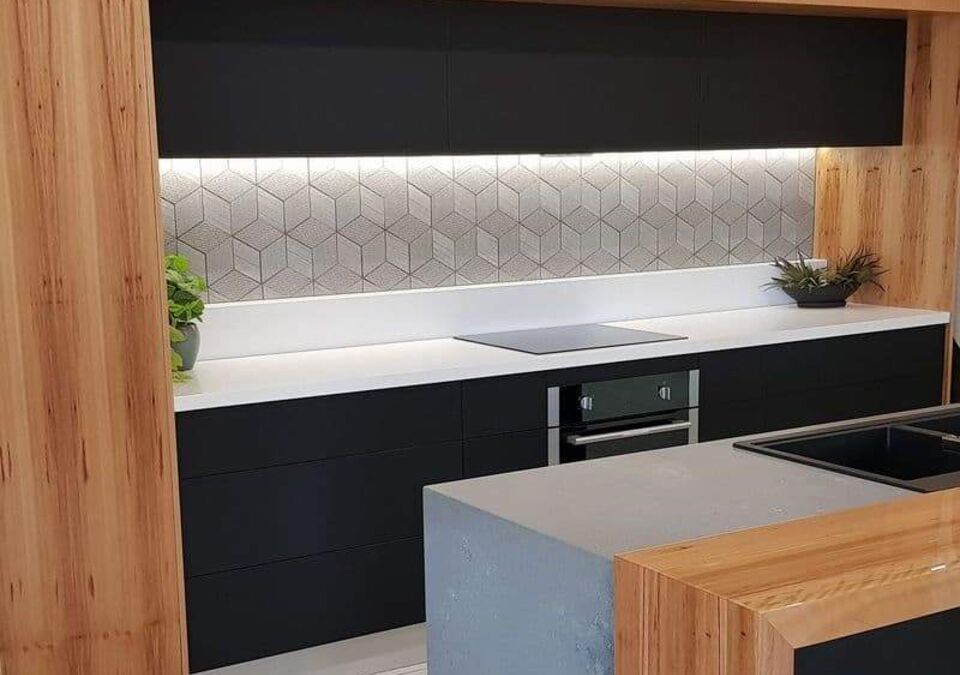 A modern kitchen with a white stone benchtop and tiled splashback