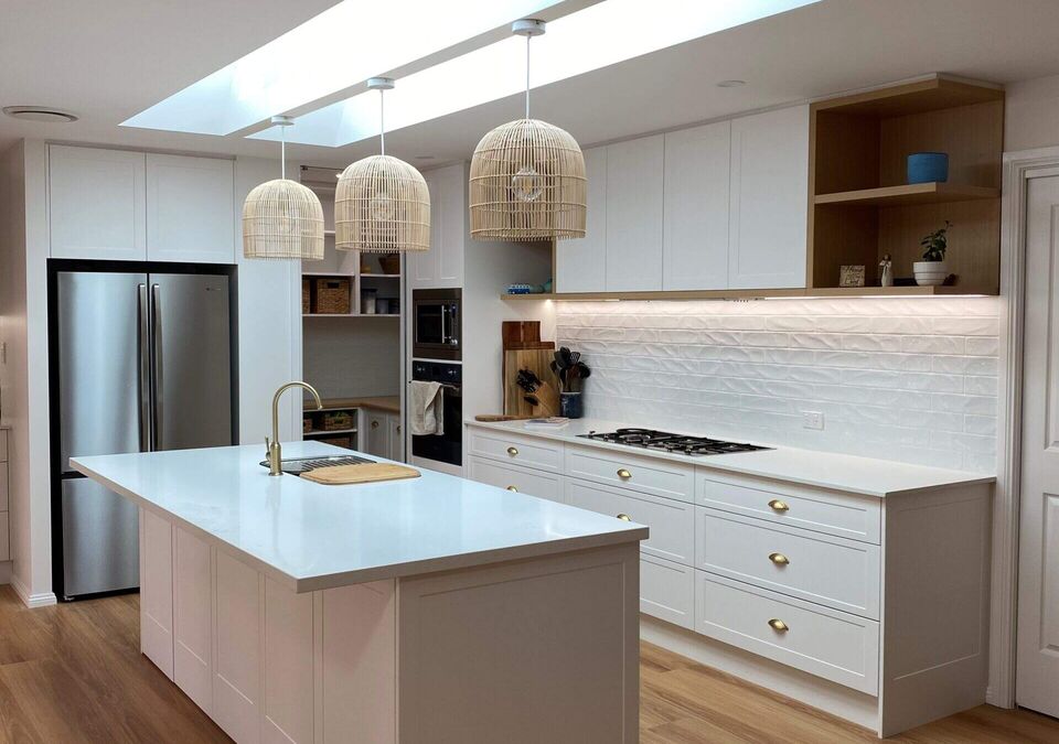 A modern kitchen with a white stone island and pendant lights