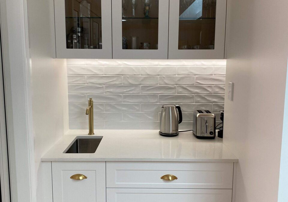 A white kitchen with a stone benchtop